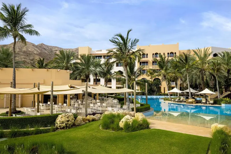 Vue d'un complexe hôtelier avec piscine et végétation luxuriante.