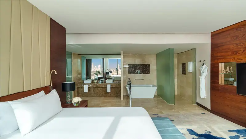 Une chambre spacieuse avec un grand lit et une salle de bain ouverte.