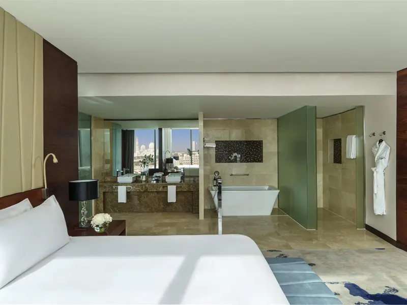 Une chambre spacieuse avec un grand lit et une salle de bain ouverte.