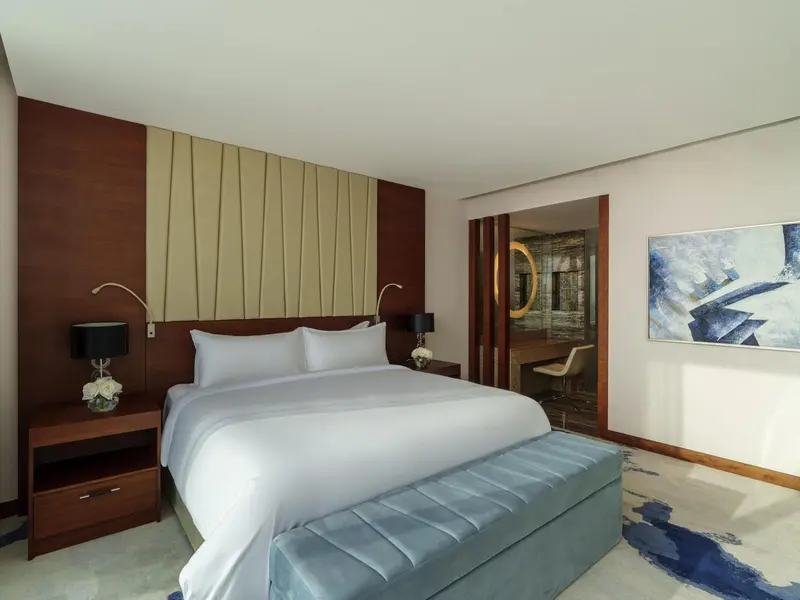 Une chambre lumineuse avec un grand lit et une décoration sobre.