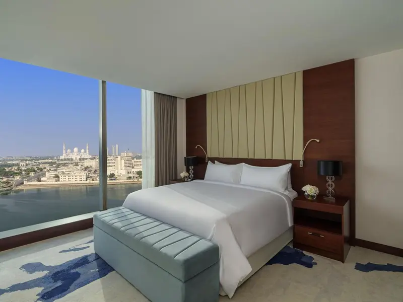 Une chambre lumineuse avec un grand lit et une vue sur la mer.