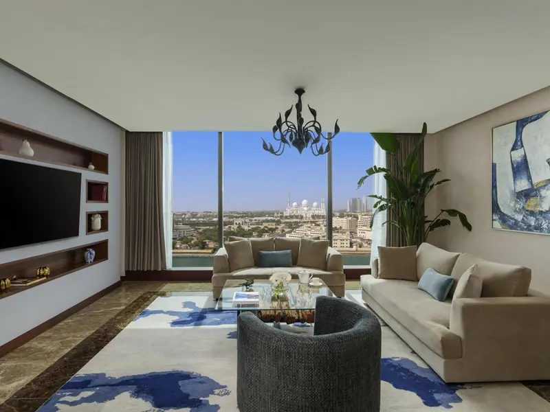 Un salon lumineux avec canapés et vue sur la ville.