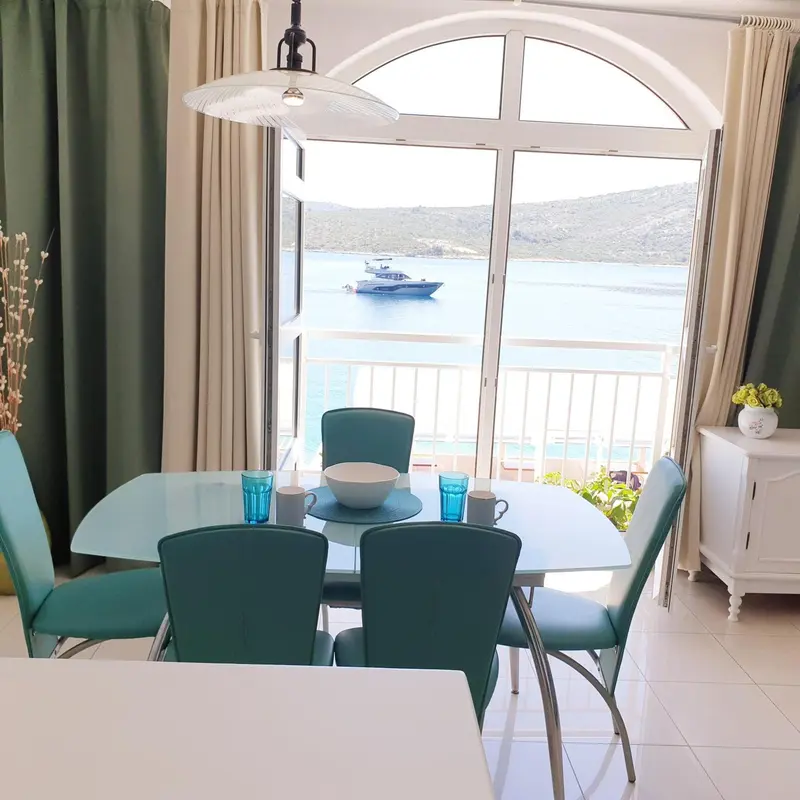Une salle à manger lumineuse s'ouvre sur une vue sur la mer.