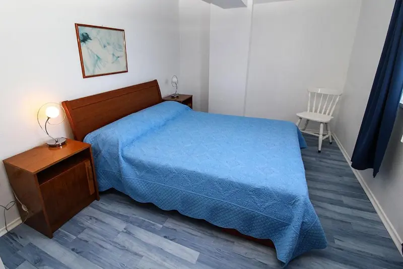 Une chambre lumineuse avec un lit fait et une chaise.
