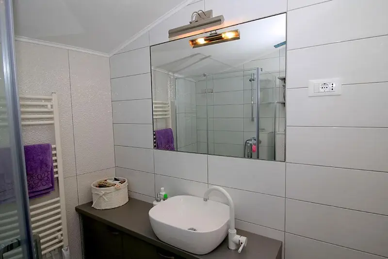 Une salle de bain moderne avec douche à l'italienne et lavabo sur vasque.