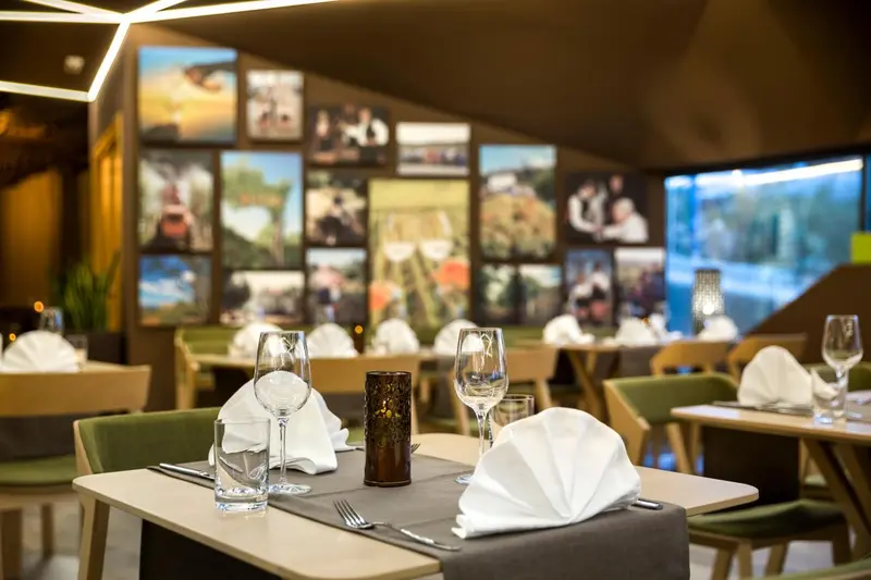 Une table est dressée dans une salle lumineuse avec des chaises et des œuvres d'art murales.
