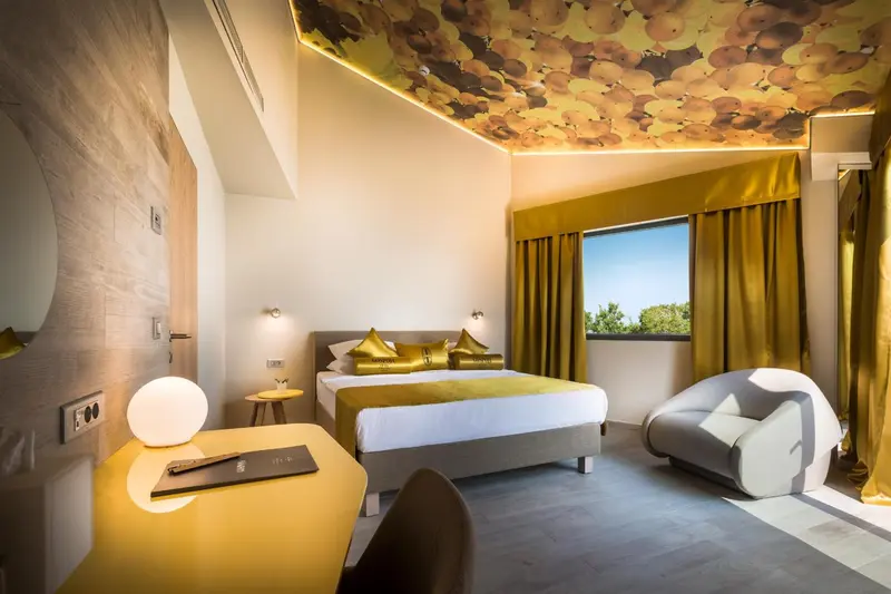 Chambre moderne avec un lit double et un éclairage chaleureux.