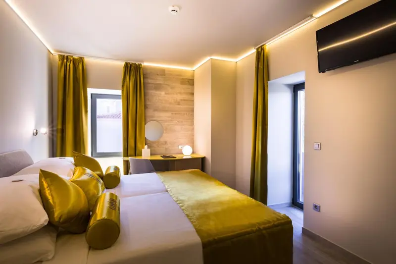 Chambre lumineuse avec un lit double et un éclairage chaleureux.