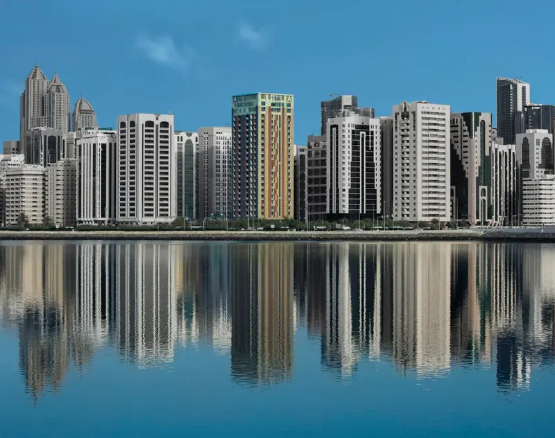Reflets de buildings modernes sur une surface d'eau calme.