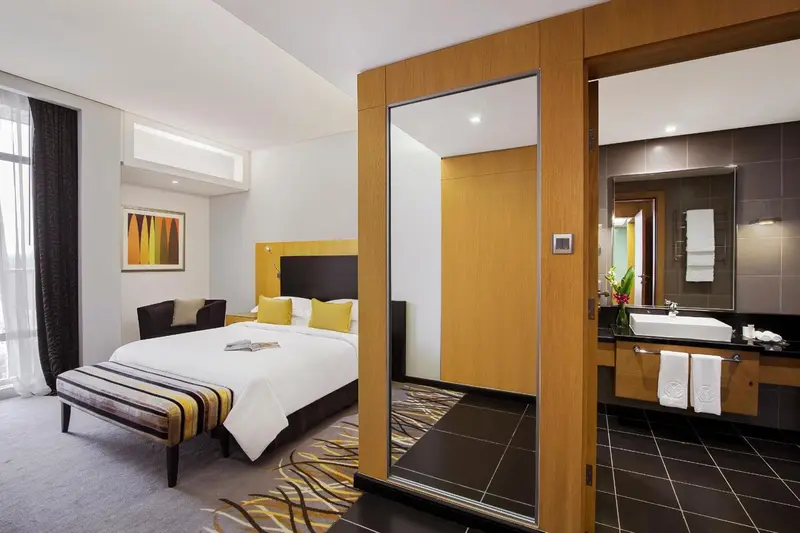 Chambre moderne avec un grand lit et un espace salle de bain attenant.