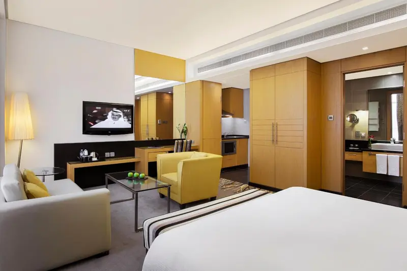 Espace de vie lumineux avec canapé, télévision et kitchenette.