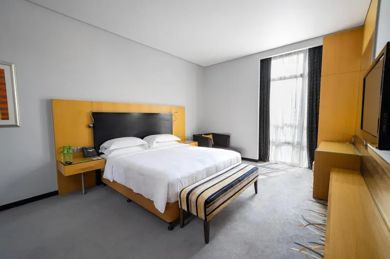 Une chambre d'hôtel lumineuse avec un grand lit et un coin salon.
