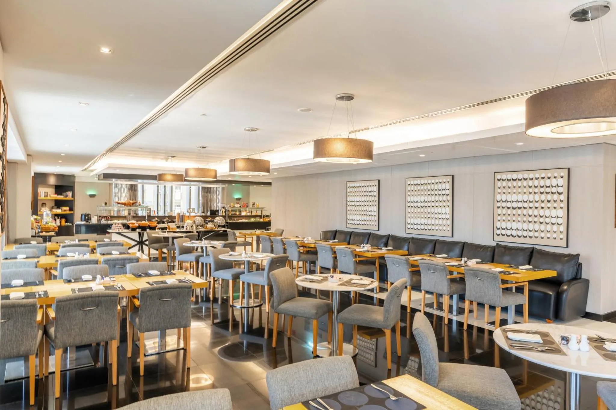 Une salle lumineuse avec des tables dressées pour le repas.