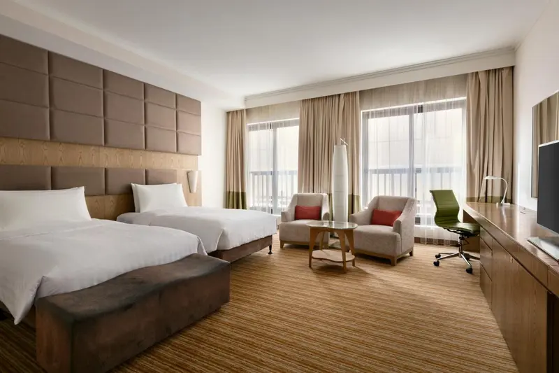 Une chambre d'hôtel lumineuse avec un grand lit et un coin salon.