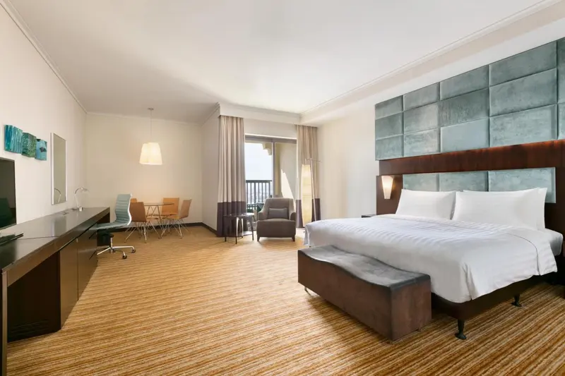 Une chambre spacieuse avec un lit double et un coin repas.