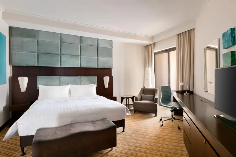 Chambre d'hôtel lumineuse avec un grand lit et un coin salon.