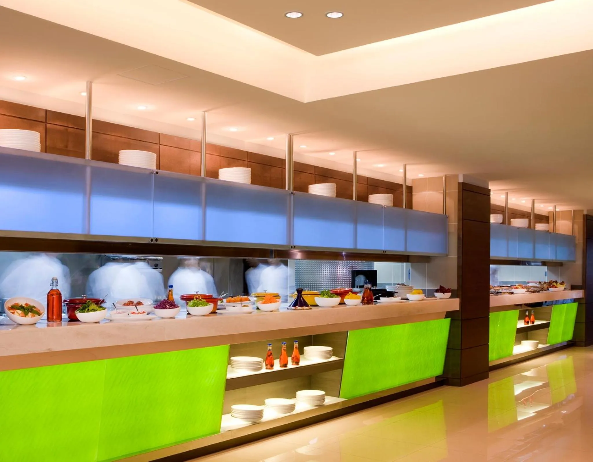 Un long buffet propose une variété de plats et de salades colorées.