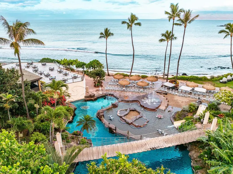 Vue aérienne d'un complexe hôtelier avec piscine et accès à la plage.