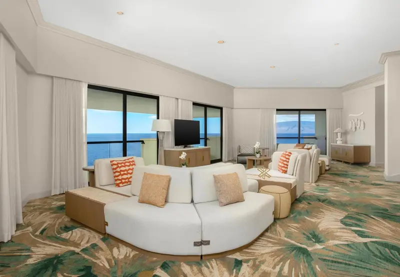Un salon lumineux avec canapés et vue sur la mer.