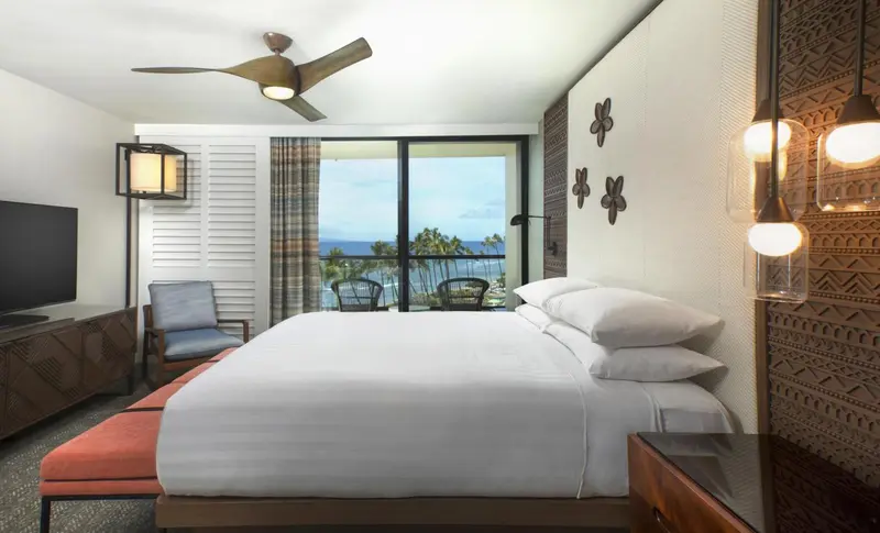 Une chambre lumineuse avec un grand lit et une vue sur la mer.