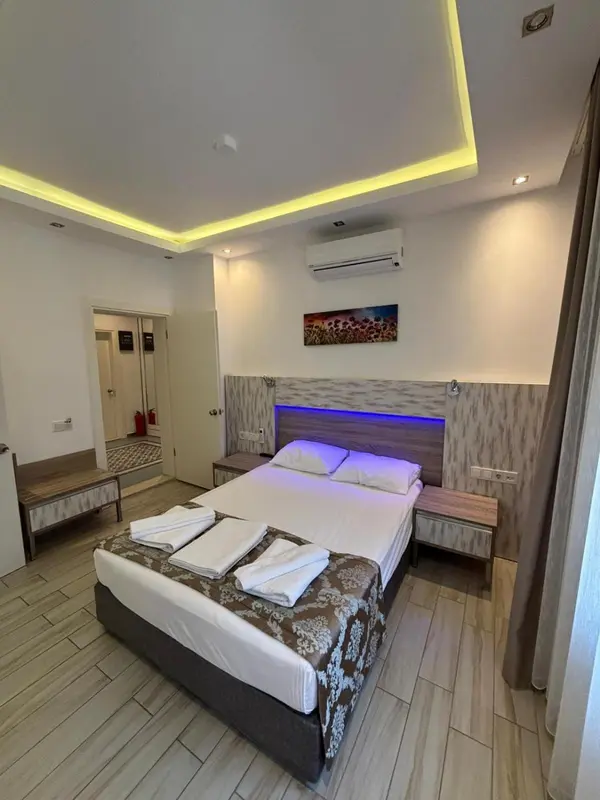 Chambre moderne avec un grand lit et un éclairage d'ambiance.
