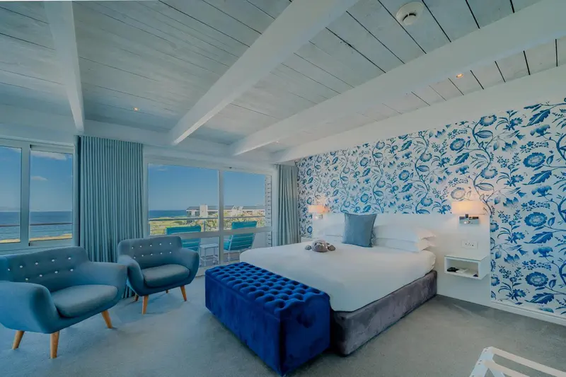 Chambre lumineuse avec un lit confortable et une vue sur la mer.