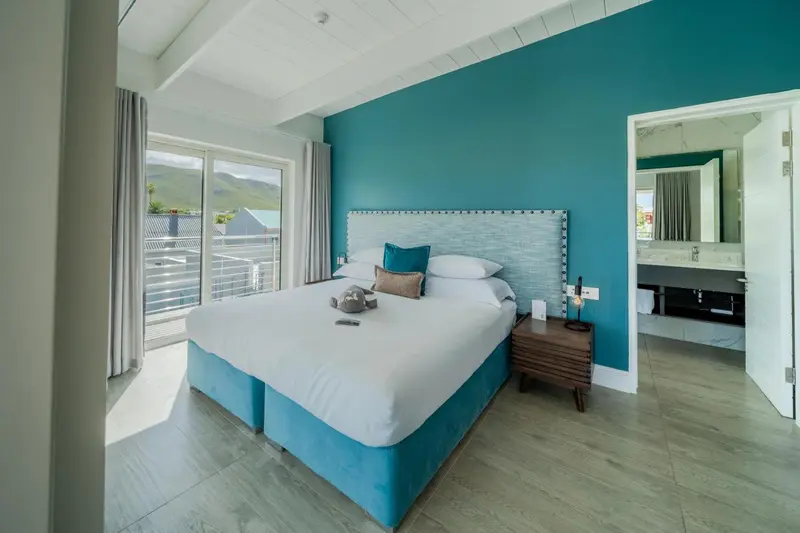 Une chambre lumineuse avec un grand lit et une vue sur l'extérieur.