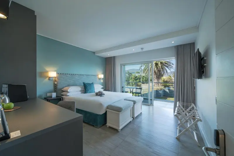 Une chambre lumineuse avec un grand lit et un accès à une terrasse.