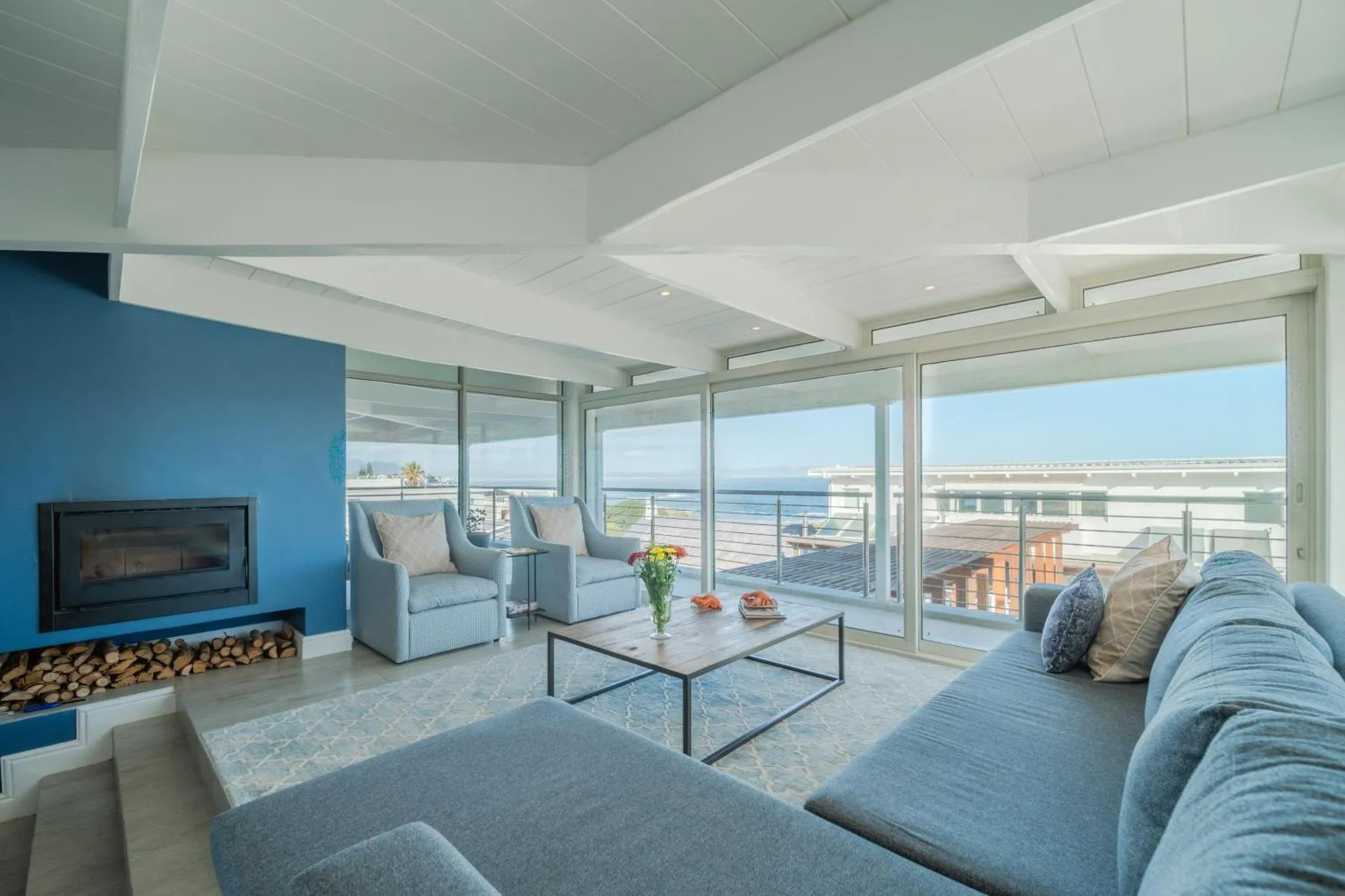 Espace de détente intérieur avec canapés et vue sur la mer.