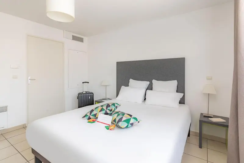 Une chambre lumineuse avec un grand lit et une décoration sobre.