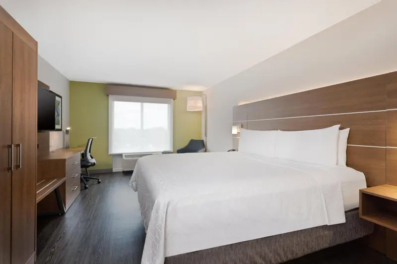 Une chambre lumineuse avec un grand lit et un bureau.