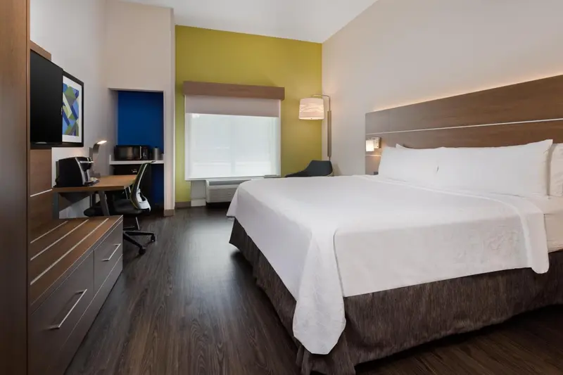 Une chambre d'hôtel lumineuse avec un grand lit et un espace de travail.