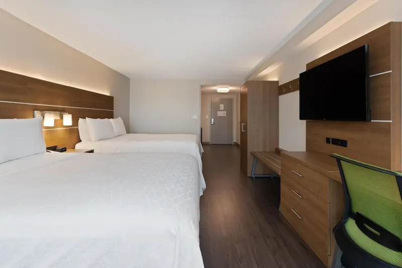 Une chambre d'hôtel moderne avec deux lits et un bureau.