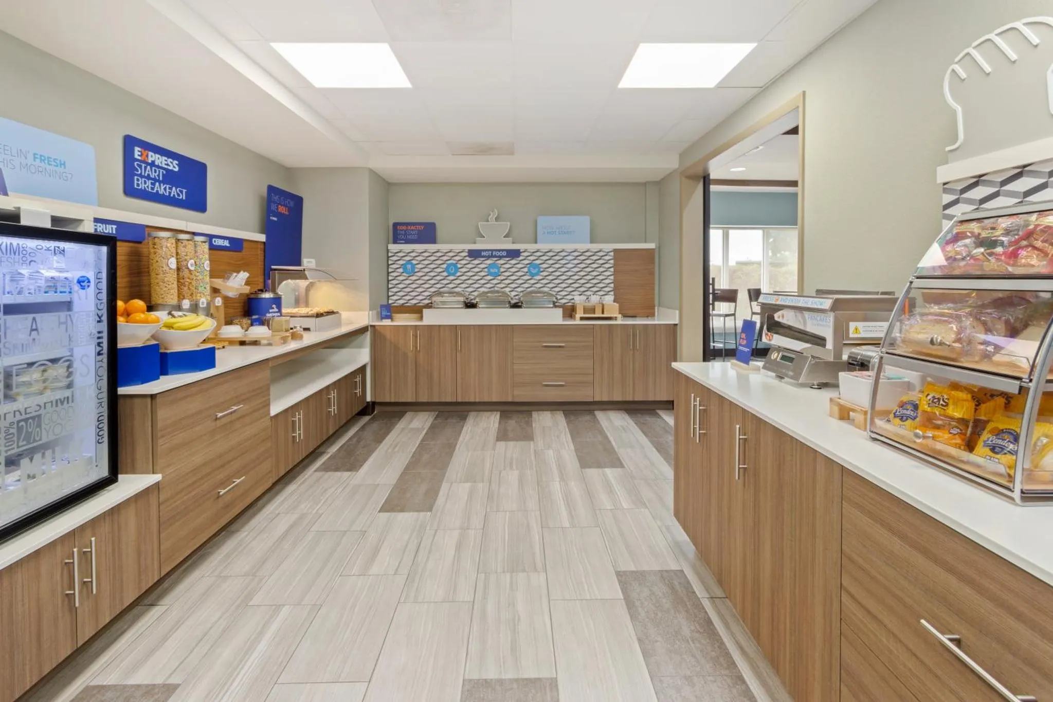 Un espace lumineux propose un buffet de petit-déjeuner avec des céréales, des pâtisseries et des boissons.