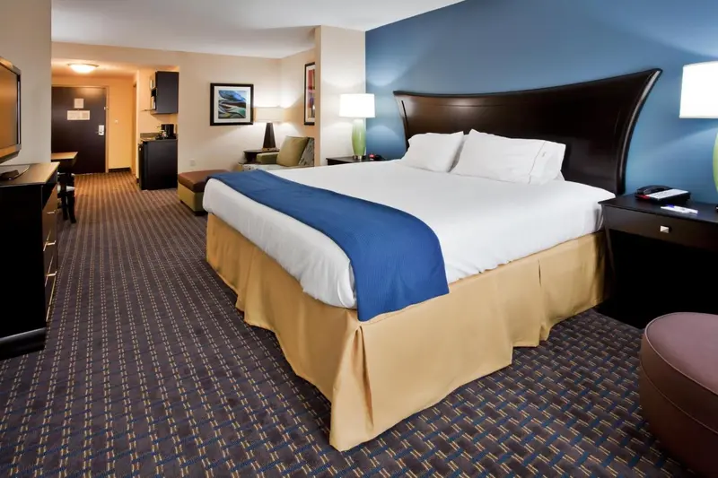 Une chambre d'hôtel avec un grand lit recouvert d'une courtepointe bleue et blanche.