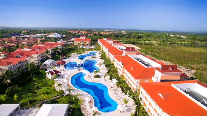 Vue aérienne d'un complexe hôtelier avec des piscines sinueuses et une végétation luxuriante.