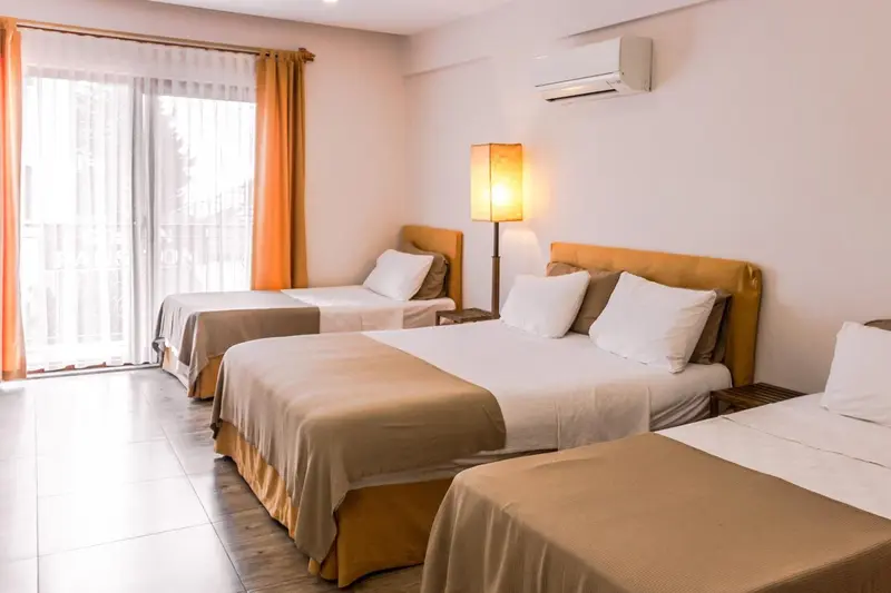 Chambre lumineuse avec deux lits simples et une décoration sobre.