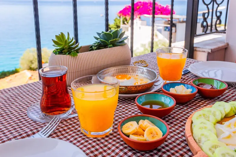 Une table est dressée avec un petit-déjeuner composé de boissons, d'œufs et de fruits.