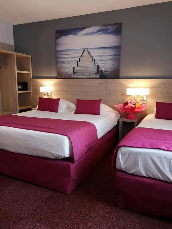 Une chambre avec deux lits et une décoration murale représentant une jetée.