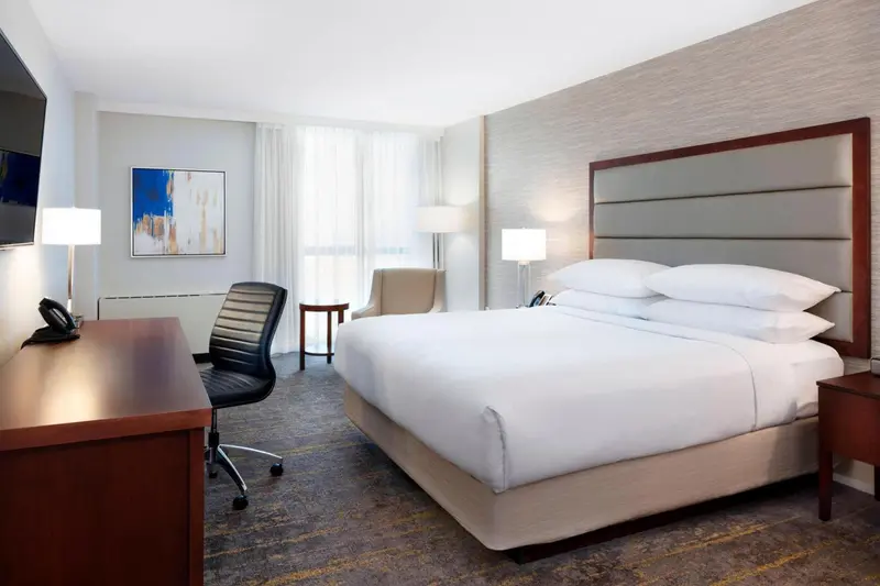 Une chambre d'hôtel lumineuse avec un grand lit et un espace de travail.
