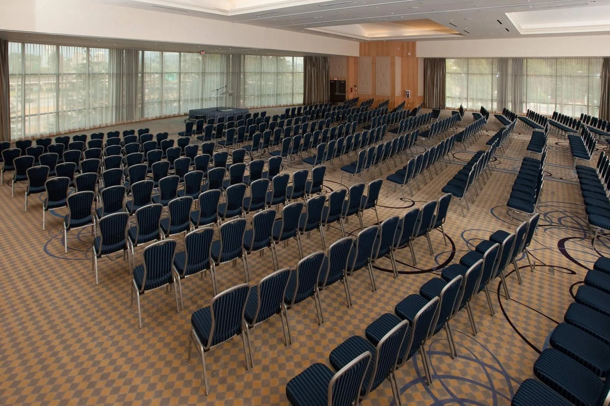 Une grande salle de conférence avec de nombreuses chaises alignées face à un podium.