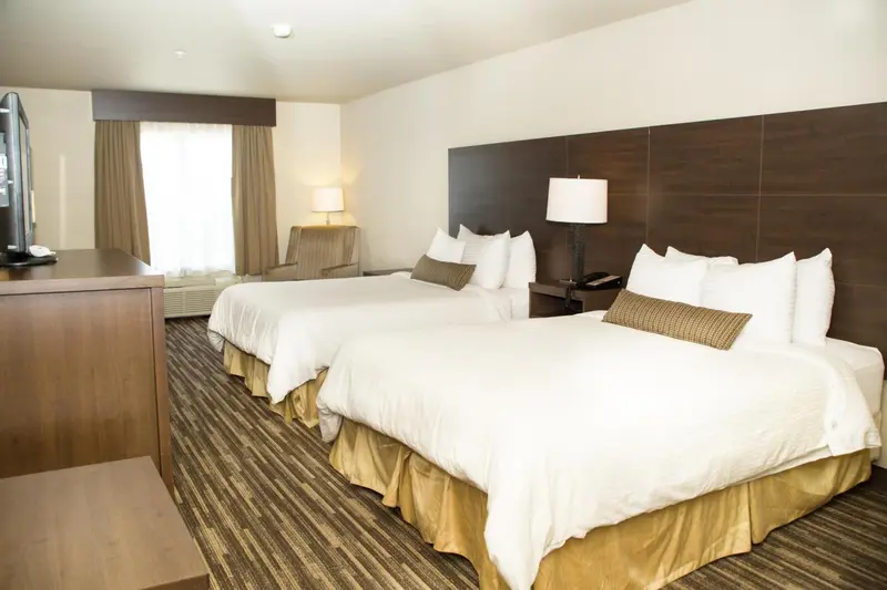 Une chambre d'hôtel avec deux lits doubles et une commode.