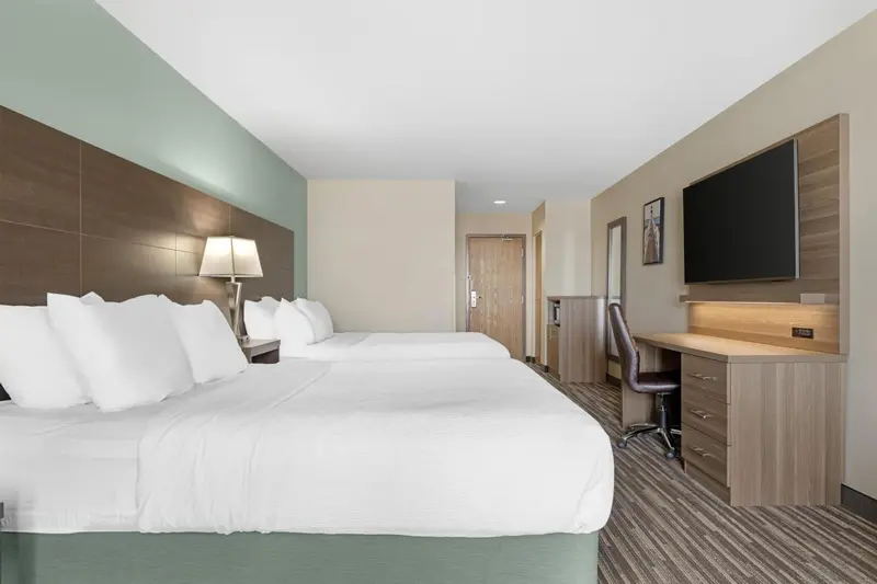 Une chambre d'hôtel avec deux lits et un bureau.