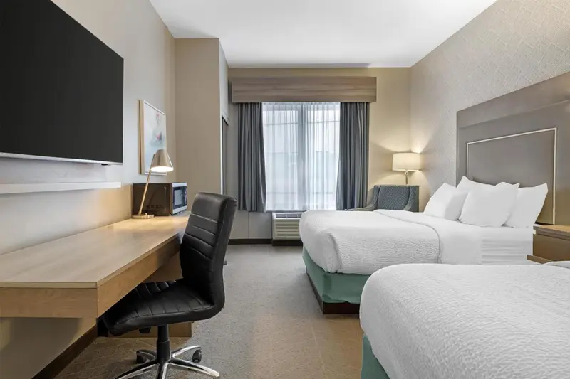 Une chambre d'hôtel lumineuse avec un bureau et un lit double.