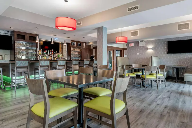 Un bar et une salle à manger avec des tables et des chaises.