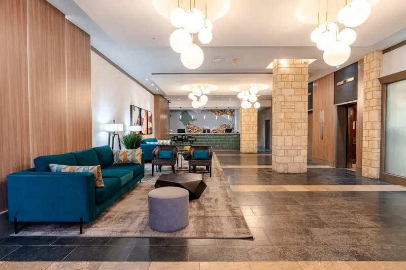 Un hall d'accueil moderne avec un canapé turquoise et un comptoir de réception.