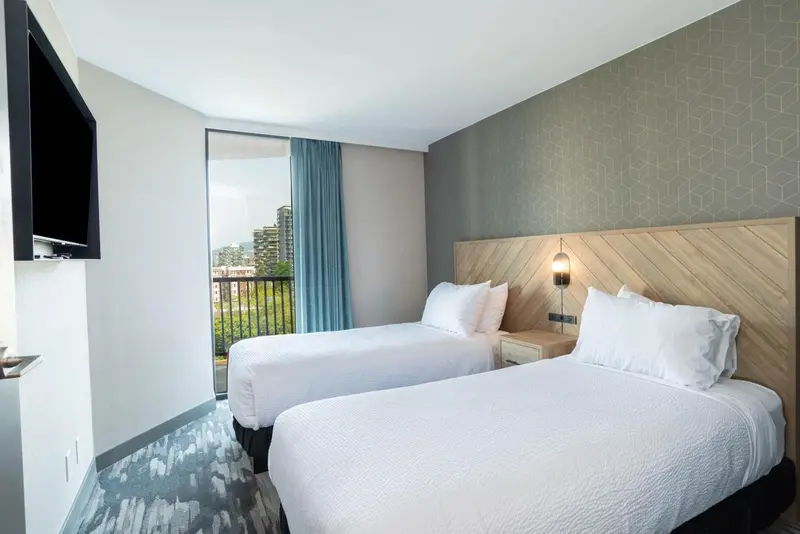 Chambre avec deux lits simples et balcon.