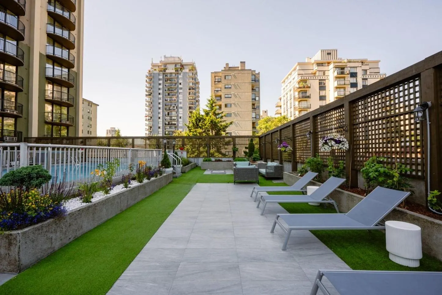 Terrasse aménagée avec des transats et une pelouse artificielle.