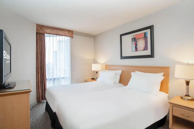 Une chambre d'hôtel lumineuse avec un grand lit et une décoration sobre.