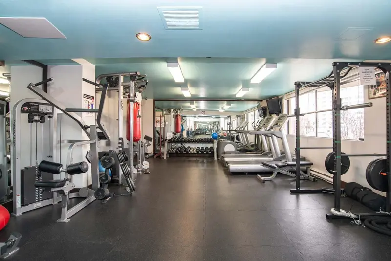 Une salle de sport lumineuse avec divers équipements de musculation et cardiovasculaire.